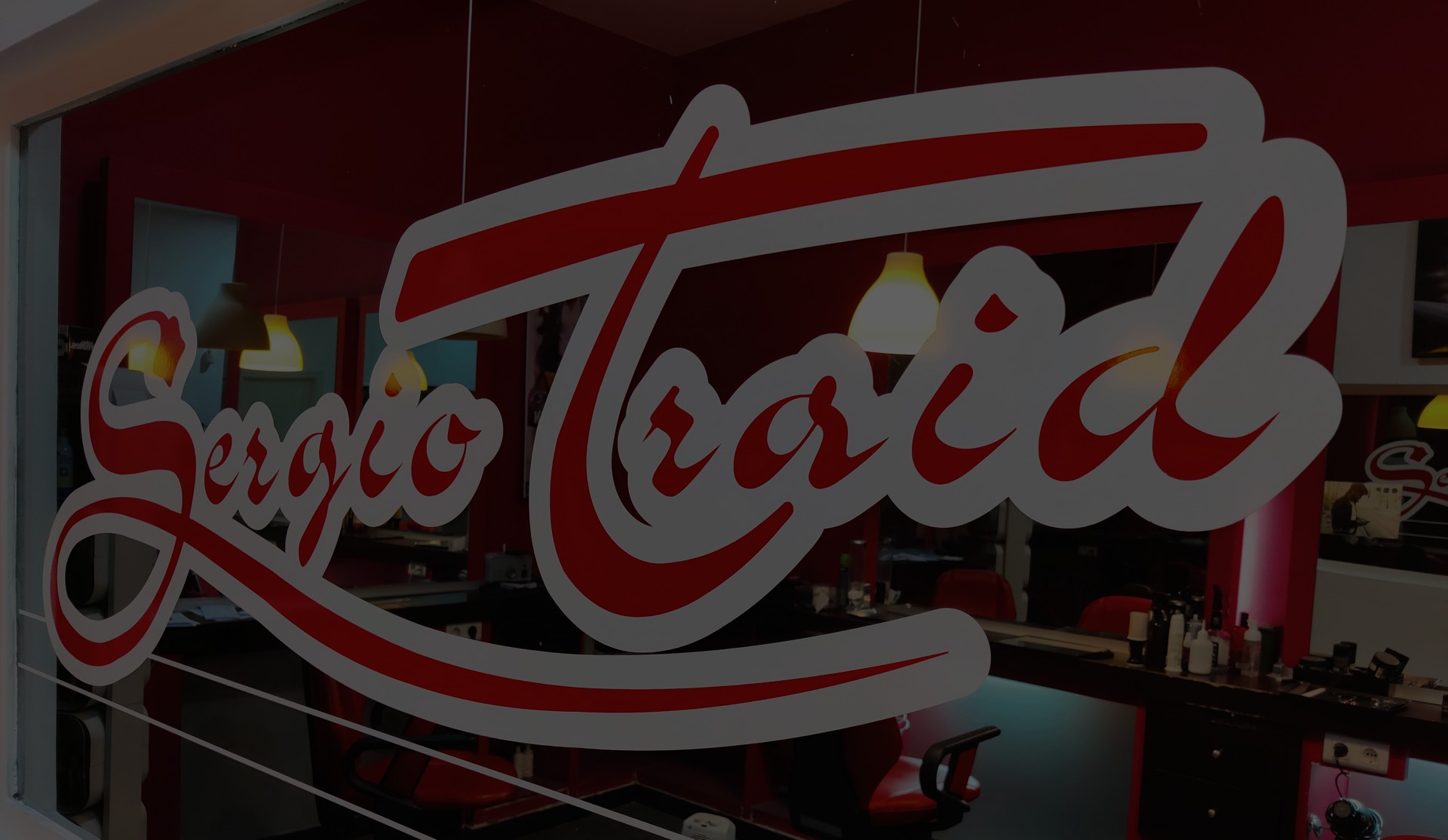 Fachada de Sergio Traid Peluqueros con el logo iluminado